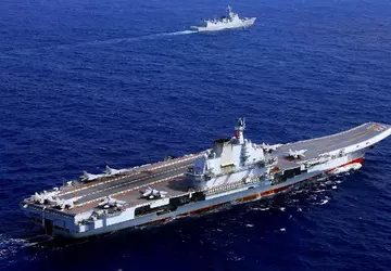 Het Chinese vliegdekschip Shandong, samen met ...